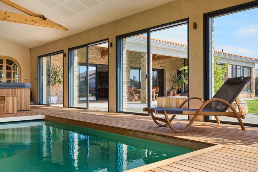 Baies coulissantes aluminium noires le long d'une piscine