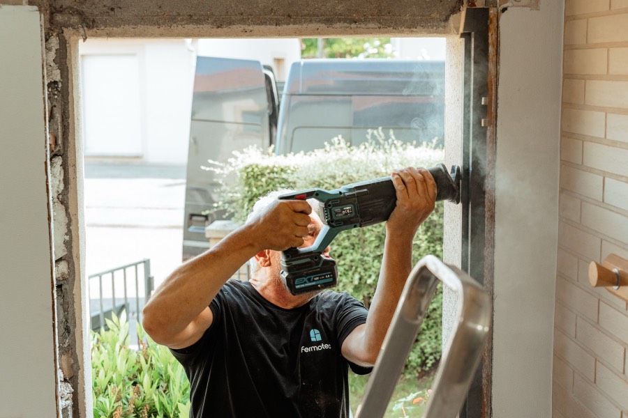 Menuisier Fermotec découpant un ancien dormant pendant une rénovation