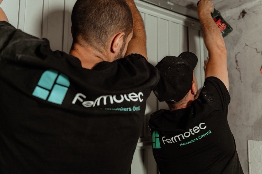 Deux menuisiers Otentik Fermotec réglant une porte de garage