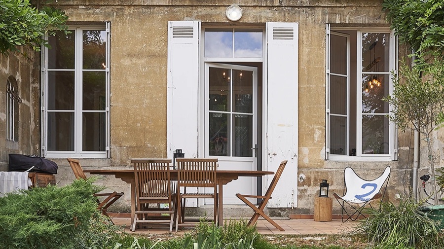 Fenêtres et porte-fenêtre en bois peint sur une façade en pierre