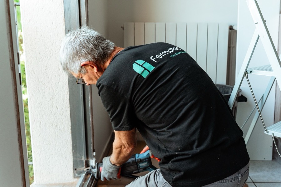 Menuisier Otentik fixant le dormant d'une fenêtre
