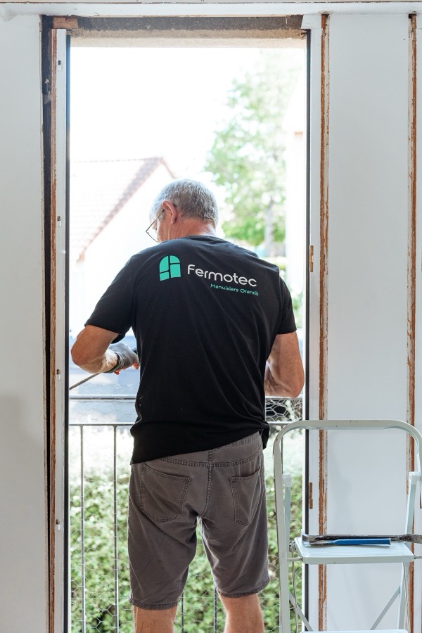 Menuisier Otentik posant une porte-fenêtre