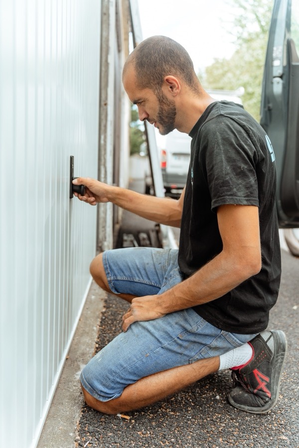 Menuisier Otentik réglant le bas d'une porte de garage