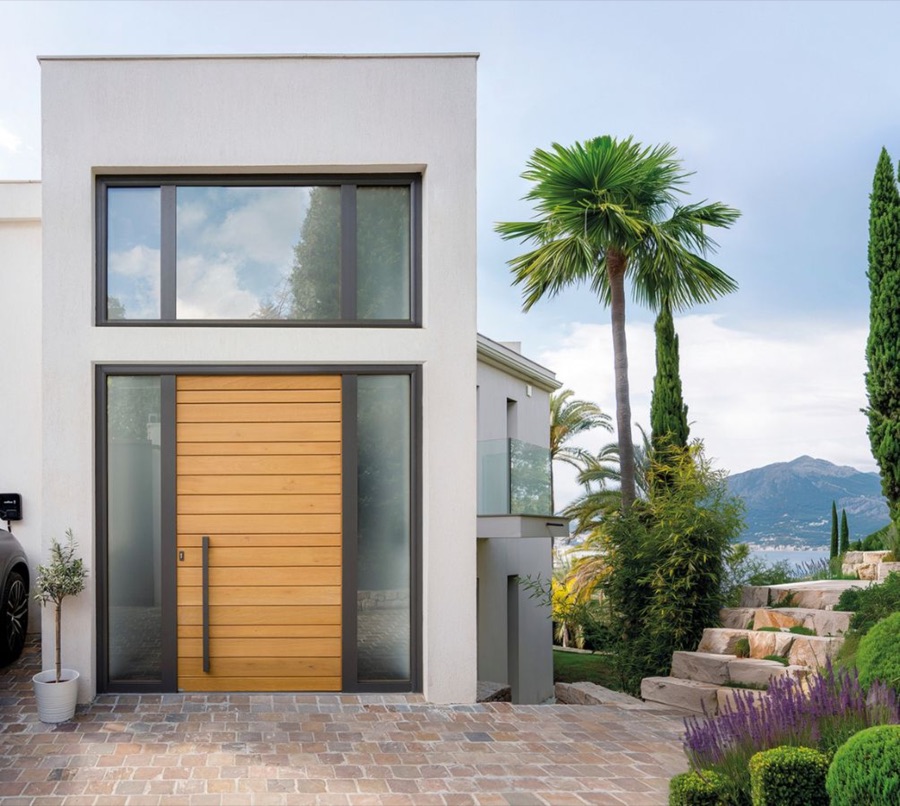 Porte d'entrée en chêne à lames horizontales sur une maison blanche