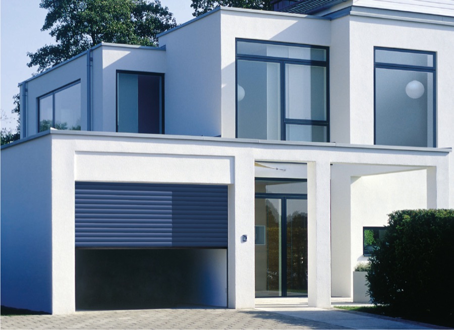 Porte de garage enroulable bleu acier sur une villa contemporaine blanche