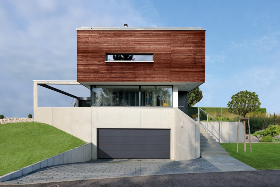 Porte de garage sectionnelle anthracite sur une maison d'architecte