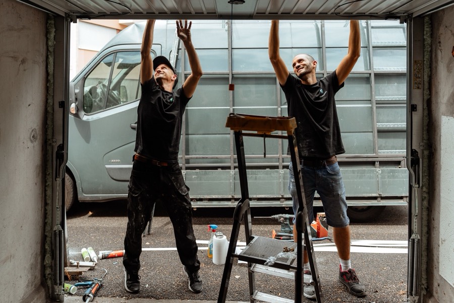Thomas et Loïc installant une porte de garage