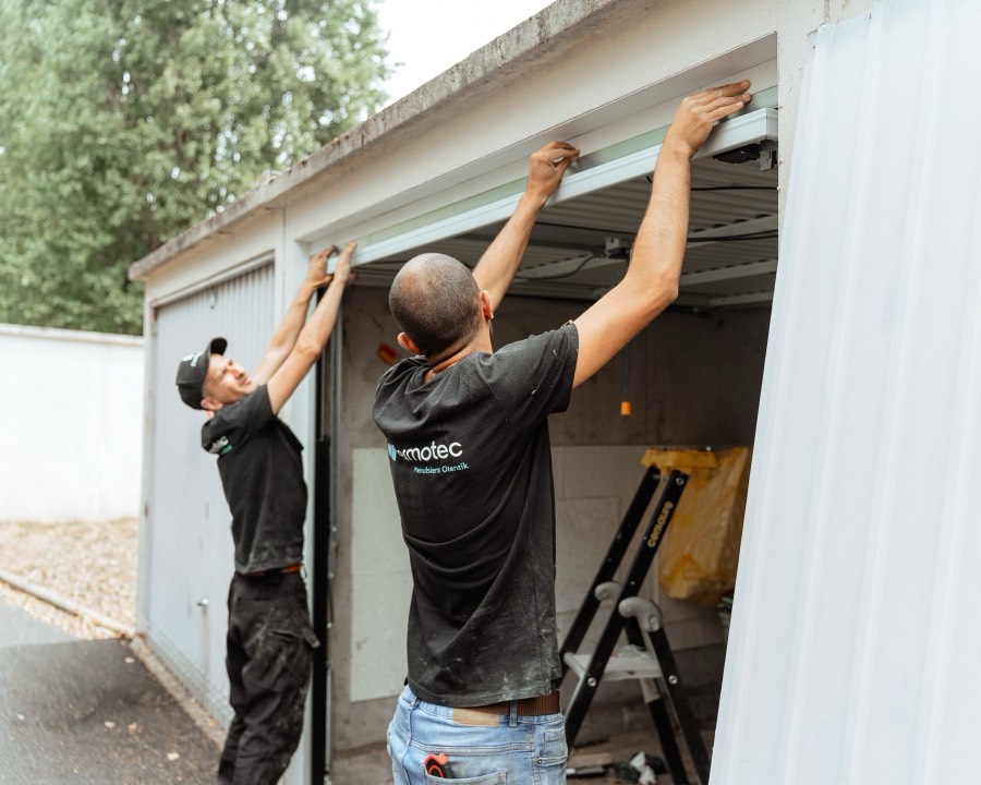 Thomas et Loïc posant une porte de garage basculante